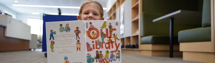 Girl holding book in the library